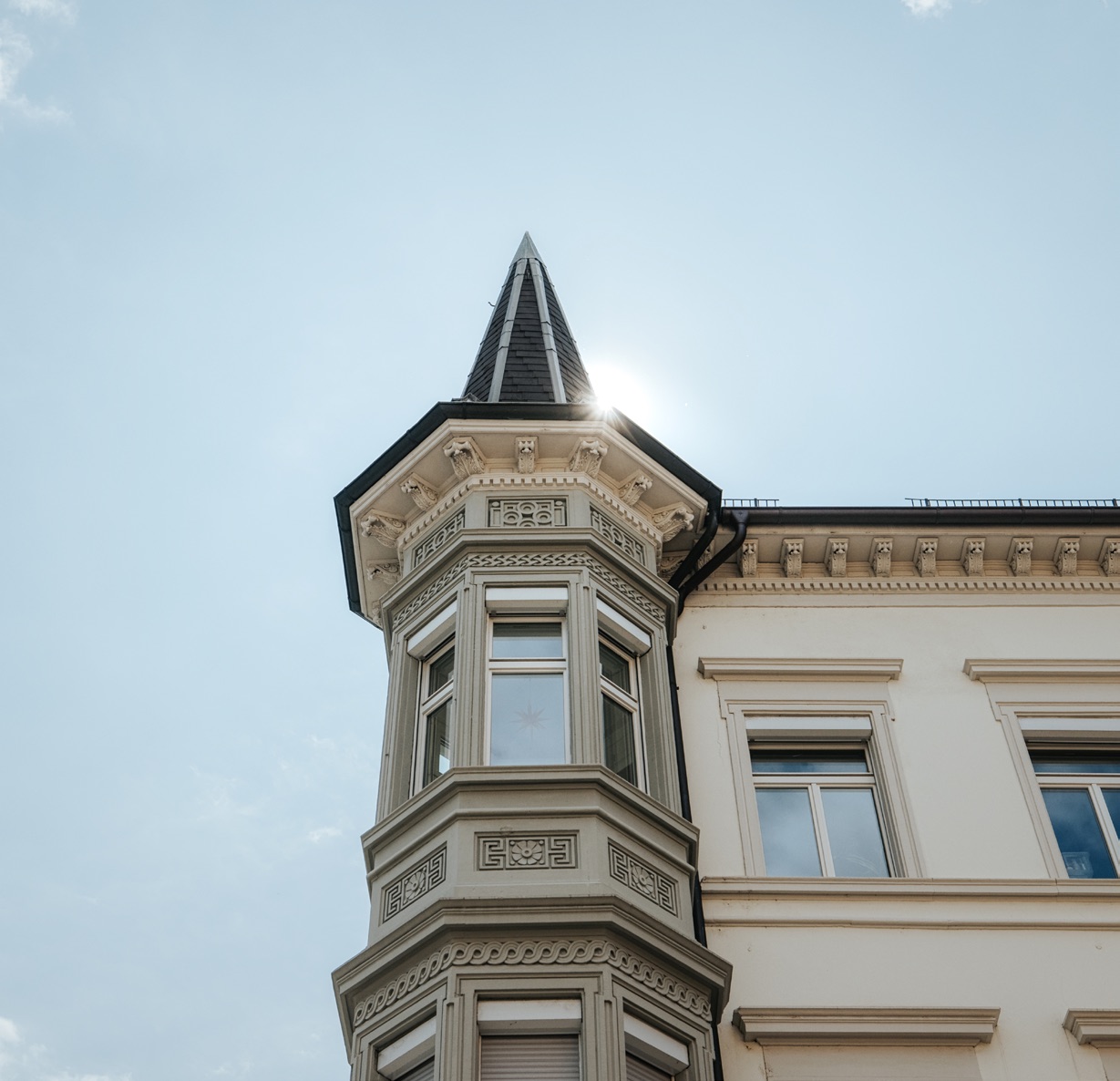 Historischer Erker eines Freiburger Altbaus vor blauem Himmel